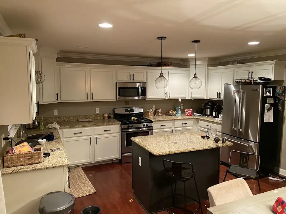 Finished kitchen cabinet refinishing project with bright white cabinetry