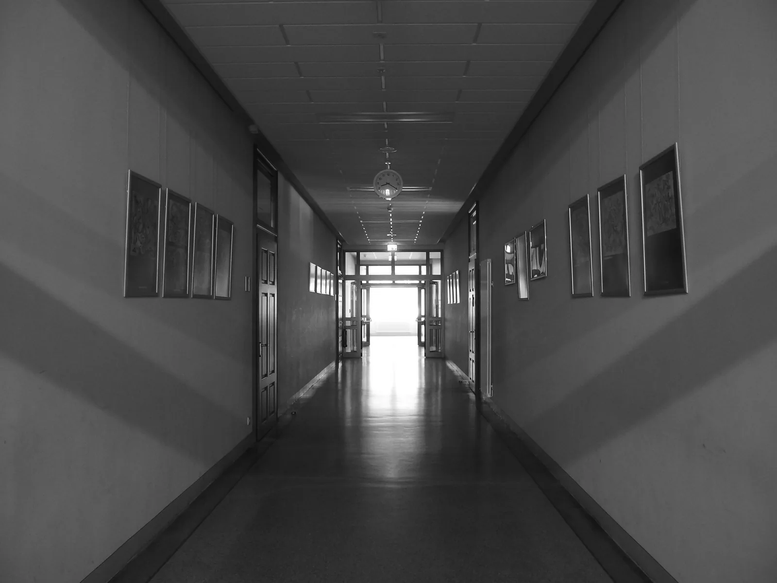 Long empty school hallway with doors and windows