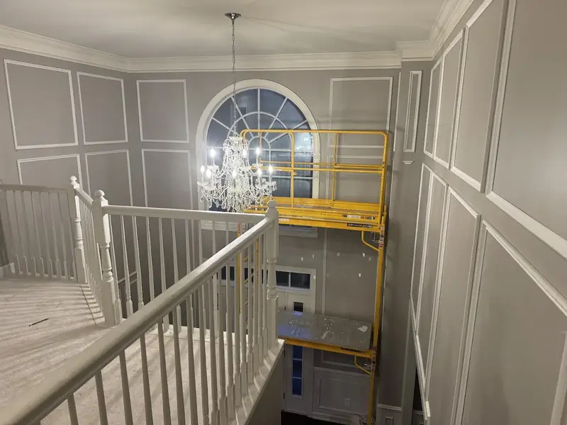 Two-story foyer with freshly painted walls, trim, and detailed molding