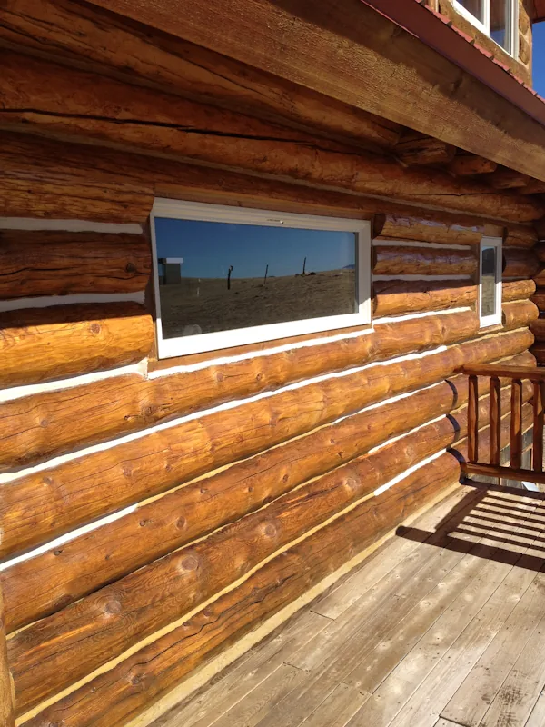 Maintained log home wall with visible wood finish and chinking