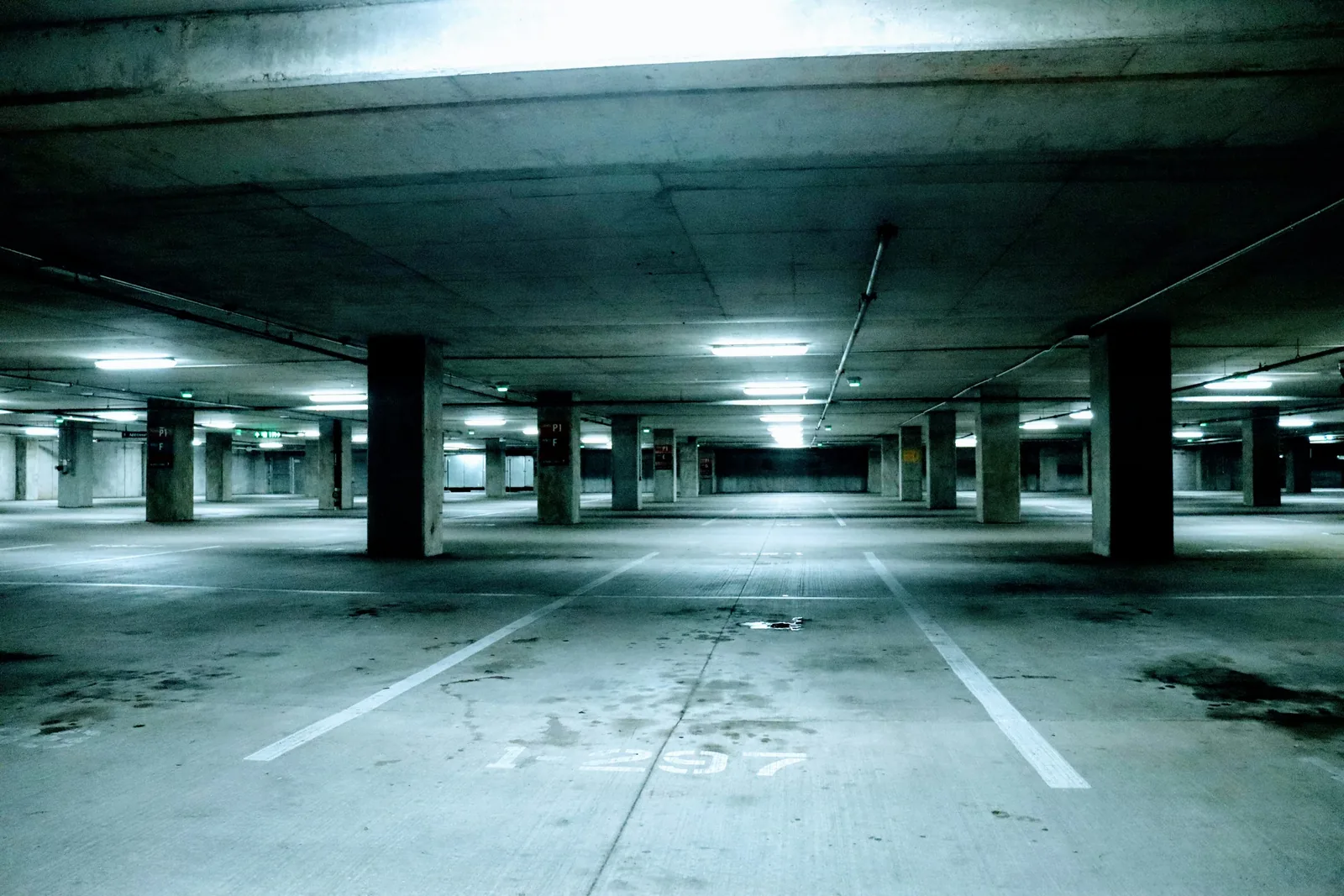 Empty parking garage with concrete columns and marked spaces