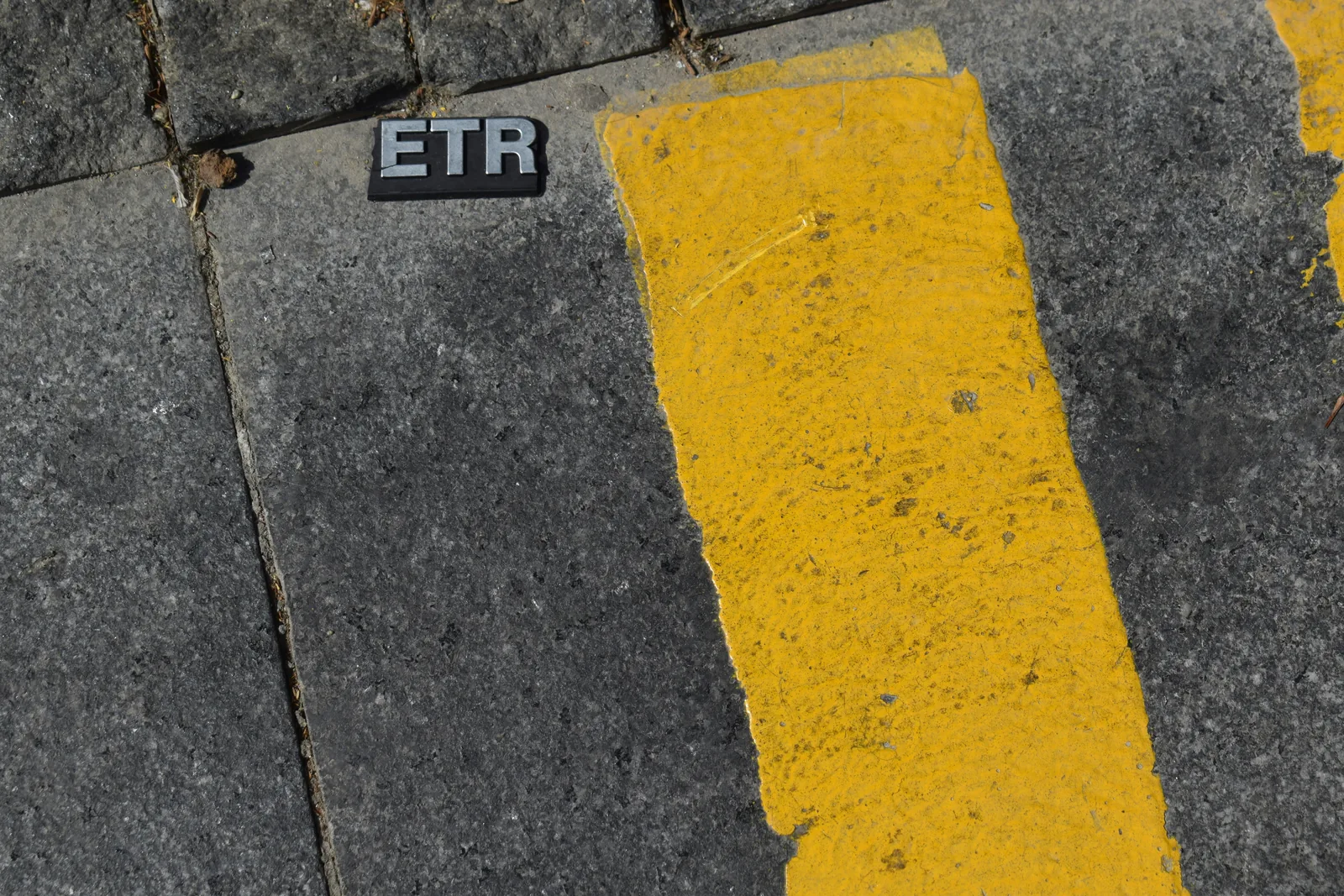 Yellow painted safety line on gray pavement
